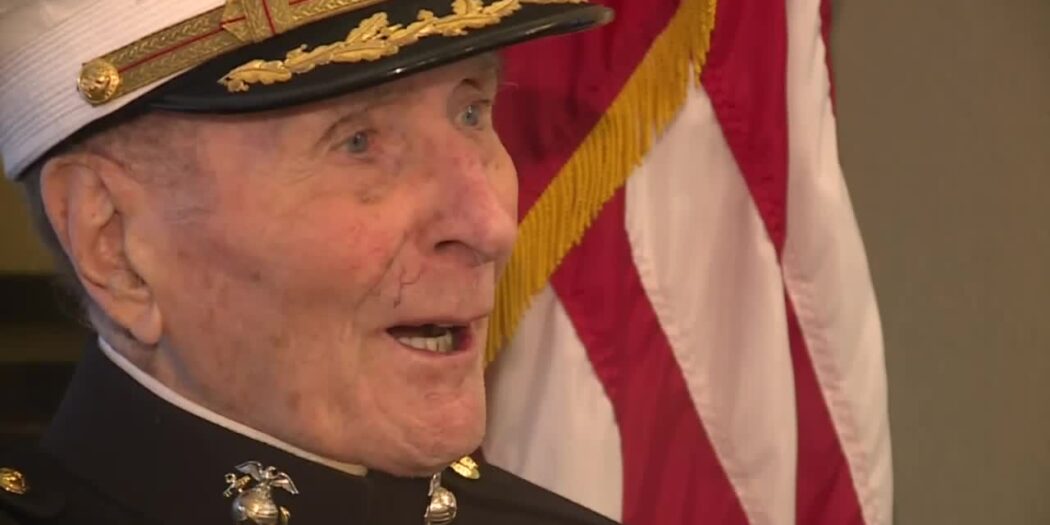 104-year-old Marine veteran Major Bill White in his dress cap next to an American flag