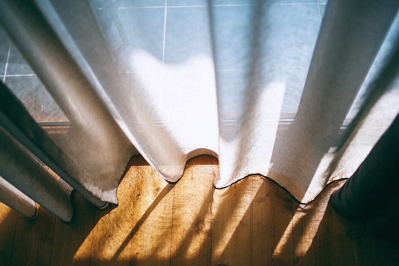 Morning sunlight through open curtains