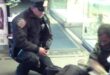 NYPD Officer Larry DePrimo kneeling beside a barefoot man in Times Square in November 2012