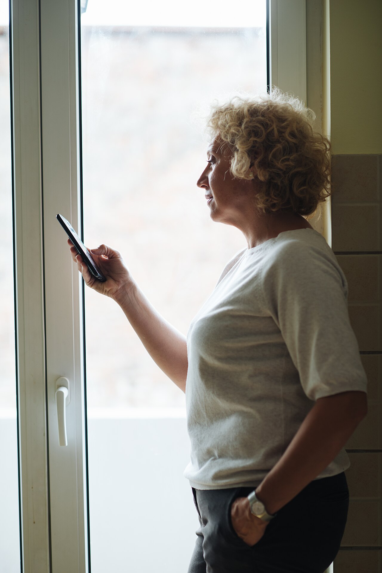 An older woman standing by a window