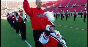 Patrick John Hughes pushes his son Patrick Henry Hughes in his wheelchair with the Louisville marching band